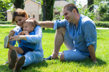 Happy family outdoor,  mother and fatther is playing with their little boy son in the park