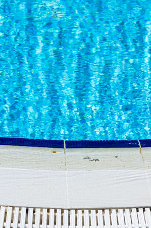 Outdoor pool in the tropical area with blue water and lader
