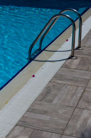 Outdoor pool in the tropical area with blue water and laderの写真素材