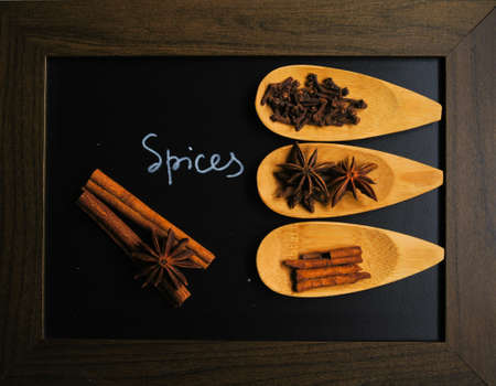 Spices like anice and cinnamon in the spoon and the chalkboardの写真素材