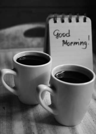 Cup of black coffee and good morning note on the tableの写真素材