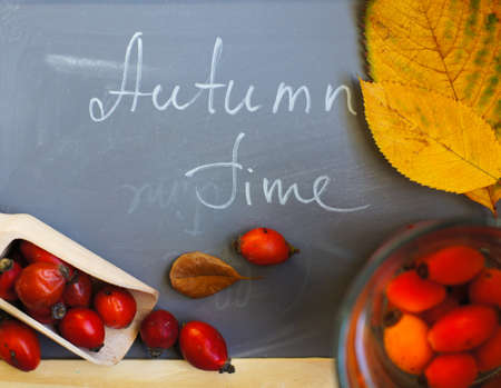 Hot hip tea with berries on the wood background and Autumn Time note on the chalkboardの写真素材