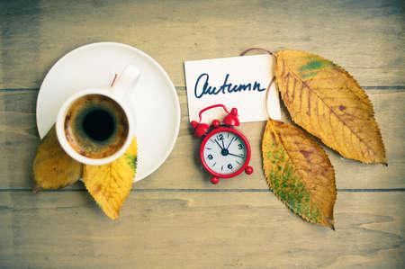 Autumn time, cup of coffee, yellow autumnal leaves and notesの写真素材