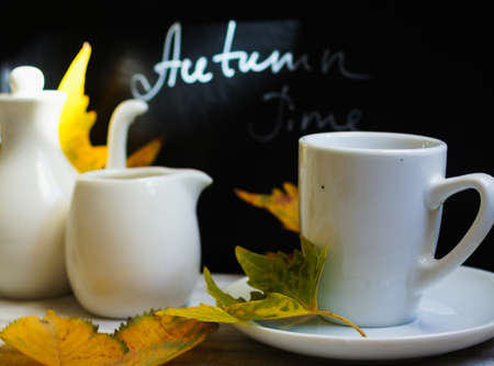 Autumn time, cup of coffee, yellow autumnal leaves and notesの写真素材