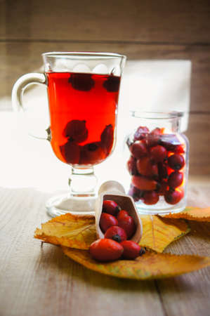 Hot hip tea with berries on the wood backgroundの写真素材