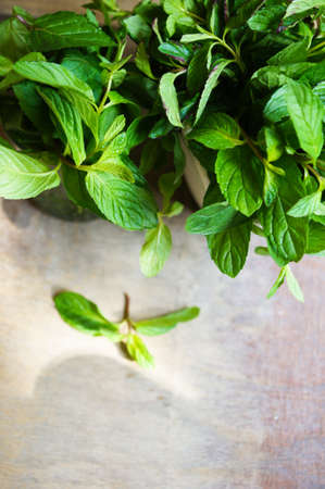 Fresh leaves of mint on the wooden background with noteの写真素材