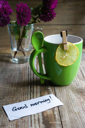 Cup of tea with lemon and flowers on the wooden tableの写真素材