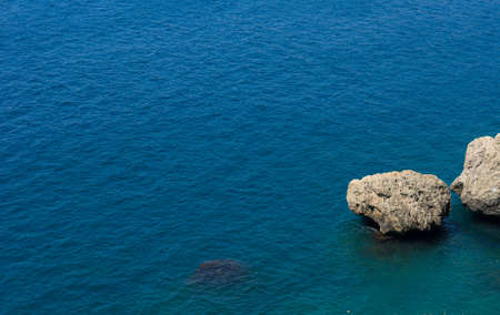 Rocks in the blue water of the seaの写真素材