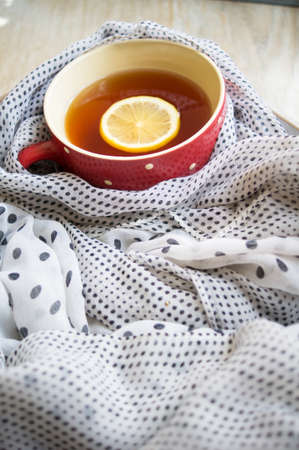 Winter time: cup of hot tea with lemon and scarfの写真素材