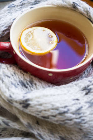 Winter time: cup of hot tea with lemon and scarfの写真素材