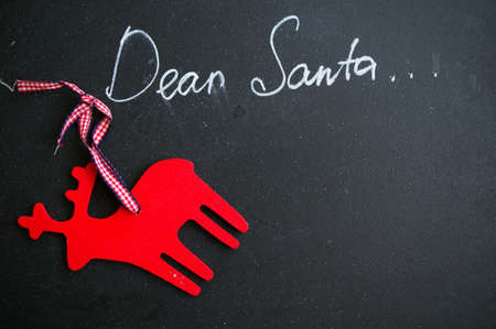 Dear Santa is written on a blackboard and christmas decorationの写真素材