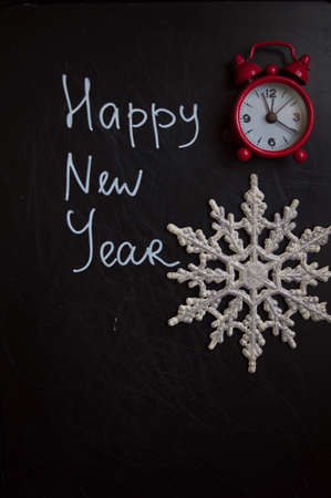 happy new year is written on a blackboard and old-styled clocks
