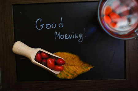 Hot hip tea with berries and Good morning note on a chalkboardの写真素材