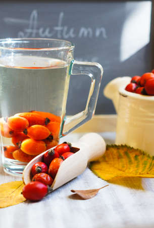 Hot hip tea with berries on the wood background and Autumn Time note on the chalkboardの写真素材