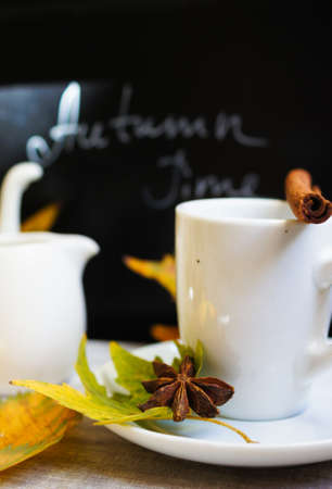 Autumn time, cup of coffee, yellow autumnal leaves and notesの写真素材