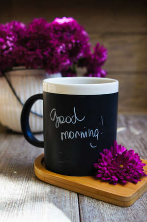 Autumn time, flowers in the vase and cup of coffee on the table with noteの写真素材