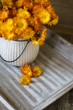 Yellow chrysanthemum flowers in a vase on the tableの写真素材