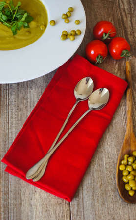 Fresh green pea soup with pea seeds and pea pods around. Selective Focusの写真素材