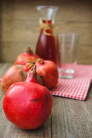 Ripe fruits of pomegranate and juice on the tableの写真素材