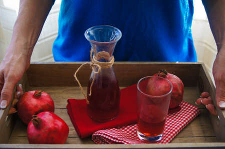 Woman hand and pomegranate fruitsの写真素材