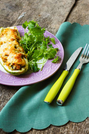 Stuffed zucchini with mushrooms and cheese on a wooden tableの写真素材