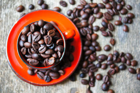Red cup of coffee with coffee beans and spices cinnamon and anise star
