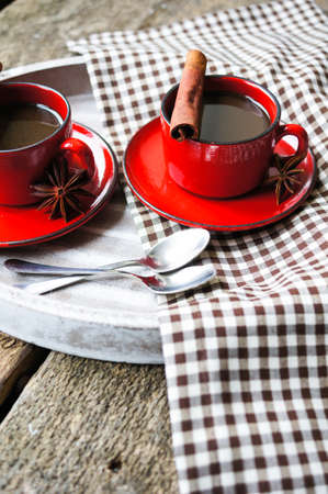 Red cup of coffee with coffee beans and spices cinnamon and anise starの写真素材