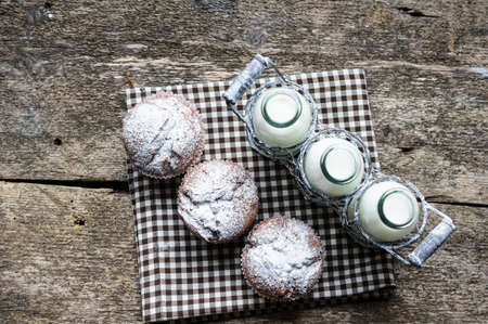 Bottles with milk and chocolate cupcakesの写真素材