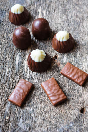 Different kinds of chocolates on wooden table close-upの写真素材