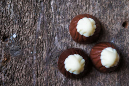 Different kinds of chocolates on wooden table close-upの写真素材