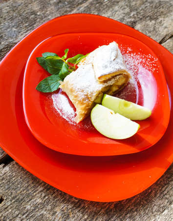 Viennese strudel with vanilla sauce on the old wooden tableの写真素材