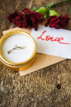 Red cloves with letter for valentine's day on the wooden backgroundの写真素材