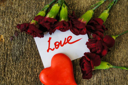 Red cloves with letter for valentine's day on the wooden backgroundの写真素材