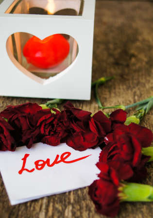 Red cloves with letter for valentine's day on the wooden backgroundの写真素材