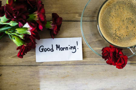 Cup of coffee with red cloves flowers for Valentine's dayの写真素材