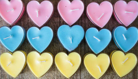 Heart shaped candles on the wooden backgroundの写真素材
