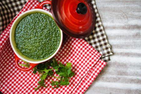 Spinach cream soup on the wooden table. Selective focus