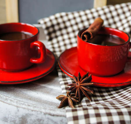 Red cup of coffee with coffee beans and spices cinnamon and anise starの写真素材