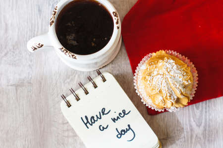 Sweet muffins and cup of black tea on the table with napkinの写真素材