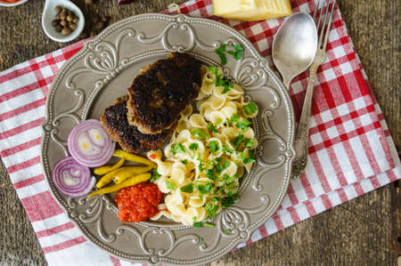 Farfalle topped with tomato sauce, vegetables and meatの写真素材
