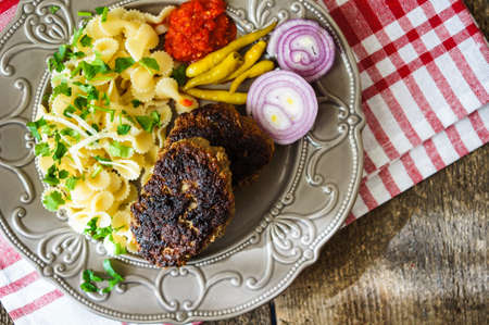 Farfalle topped with tomato sauce, vegetables and meat