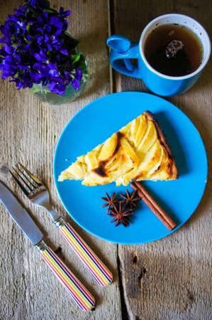 French apple tart on the old rustic table with flowers and napkinの写真素材