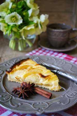 French apple tart on the old rustic table with flowers and napkinの写真素材