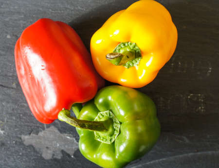 Fresh vegetables, different colors of bell pepper on the wooden backgroundの写真素材