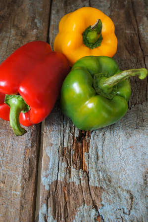 Fresh vegetables, different colors of bell pepper on the wooden backgroundの写真素材