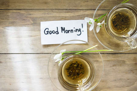 cup of green tea and spring white snowdrop flowers, rustic still life