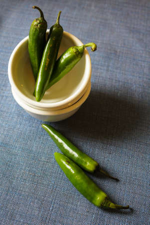 A pile of green banana peppers on the old wooden tableの写真素材
