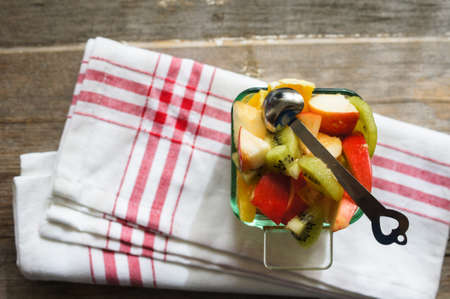 Fruit salad in a bowl on the napkin on the table
