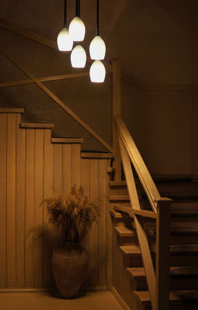 Indoor stairs in the evening with lamp and plant decorationの写真素材