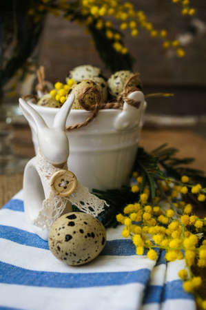 Easter time, Hand decorated Easter Eggs and speckled birds eggs in straw with a branch of colorful...